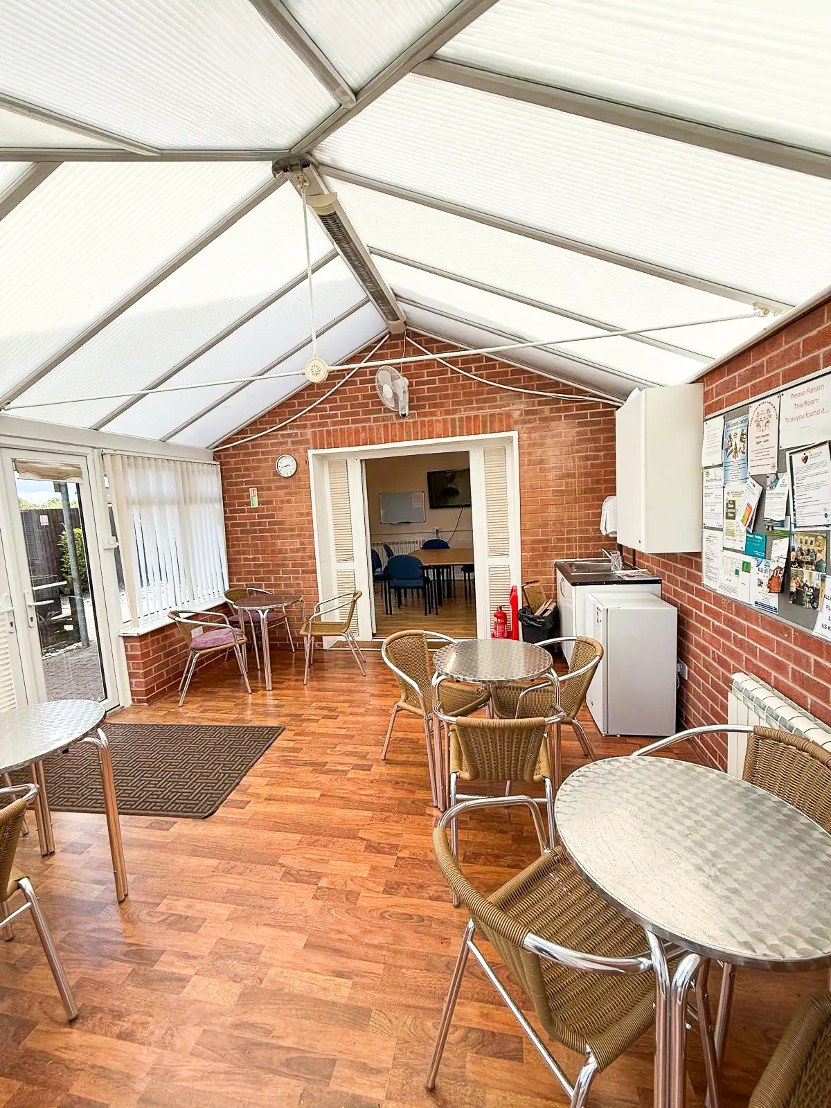 The bright conservatory room at Caring Places, used for breaks, social time and refreshments