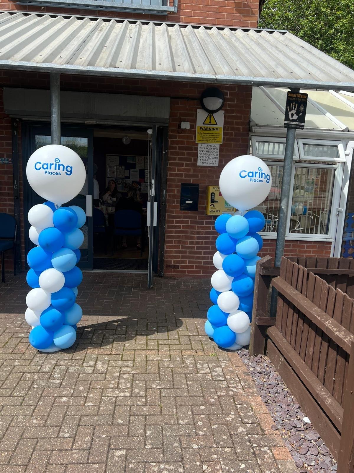 The welcoming entrance to Caring Places at Sinfin Community Centre with branded balloons either side of the door
